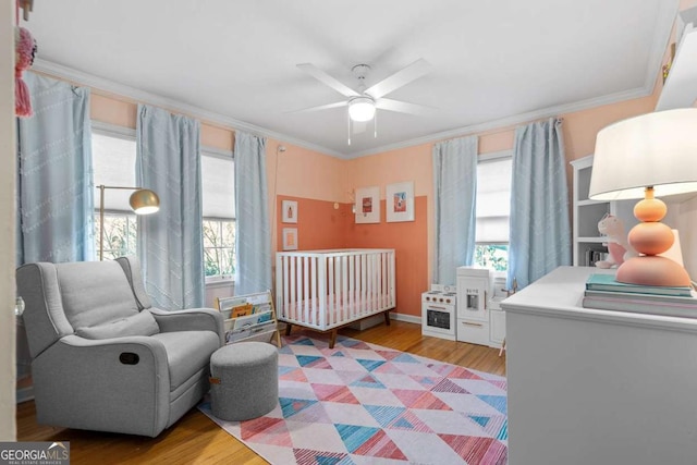 bedroom with a ceiling fan, light wood-type flooring, and crown molding