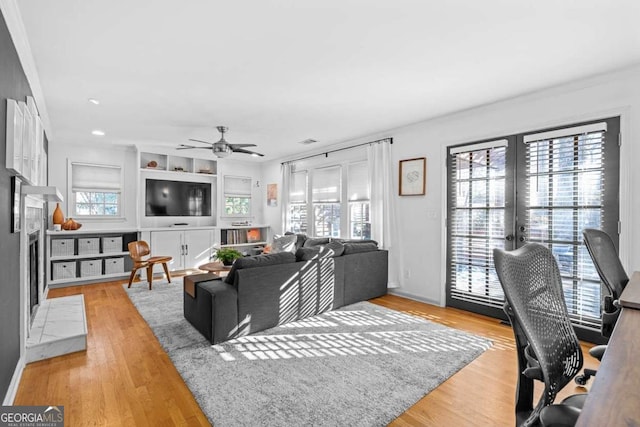 living room featuring french doors, visible vents, ceiling fan, and light wood-style flooring