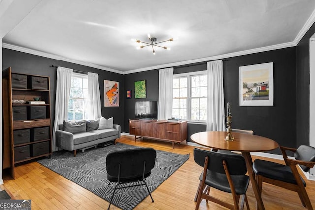 living room featuring baseboards, ornamental molding, and light wood-style floors