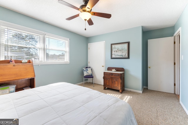 bedroom with a textured ceiling, baseboards, a ceiling fan, and light colored carpet