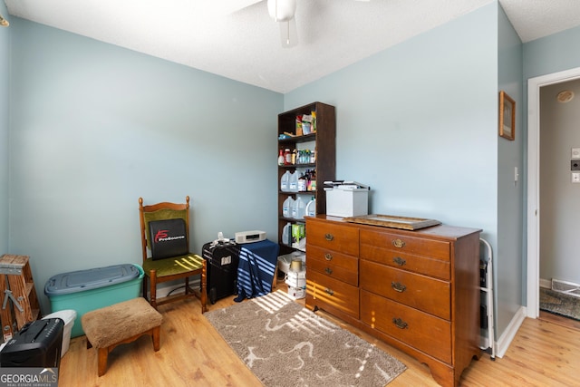 interior space featuring ceiling fan, wood finished floors, visible vents, and baseboards