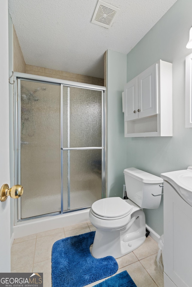 bathroom with toilet, a stall shower, visible vents, and tile patterned floors