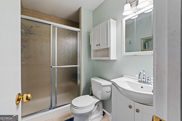 bathroom featuring a textured ceiling, a stall shower, vanity, and toilet