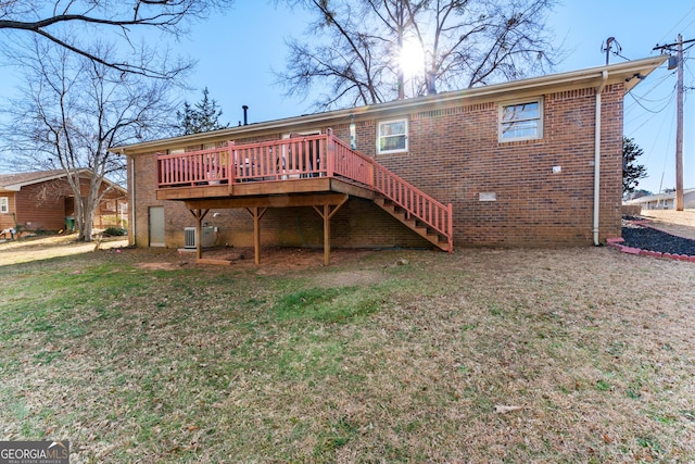 rear view of house featuring brick siding, a lawn, a wooden deck, and stairway