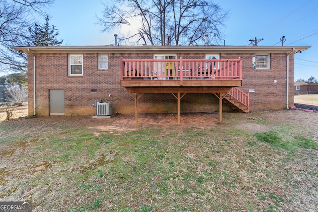 rear view of property featuring a wooden deck, crawl space, a yard, central AC, and brick siding