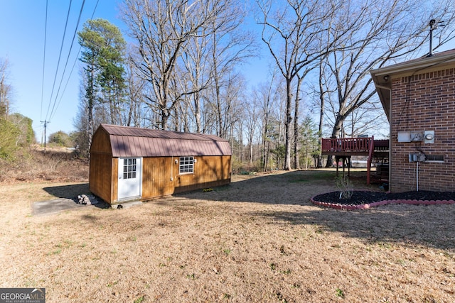 view of yard featuring an outdoor structure, a deck, and a shed