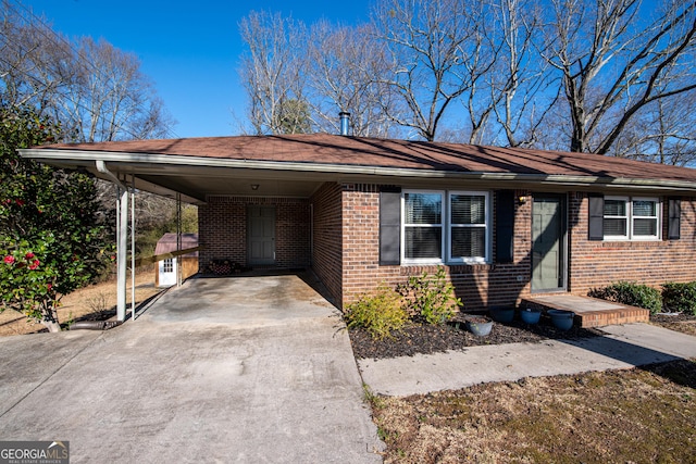 ranch-style home with a carport, concrete driveway, and brick siding