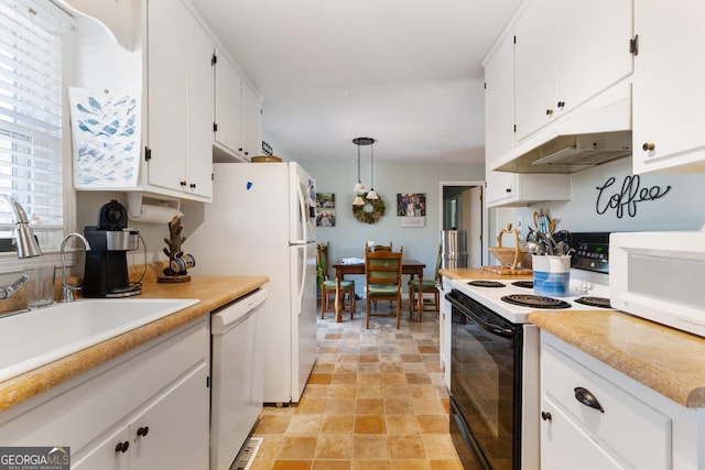 kitchen featuring under cabinet range hood, white appliances, a sink, white cabinets, and stone finish floor