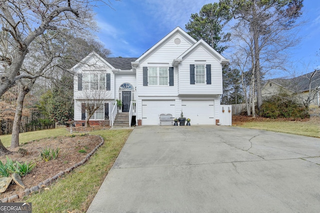 split foyer home featuring an attached garage, a front lawn, and concrete driveway