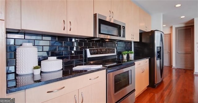 kitchen with recessed lighting, stainless steel appliances, dark wood-type flooring, backsplash, and dark stone counters