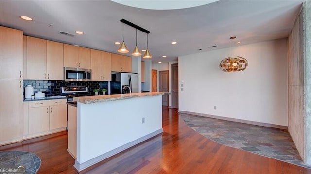 kitchen with stainless steel appliances, visible vents, dark wood finished floors, and backsplash