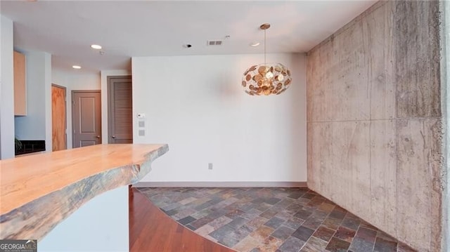 kitchen featuring recessed lighting, visible vents, baseboards, stone finish flooring, and pendant lighting