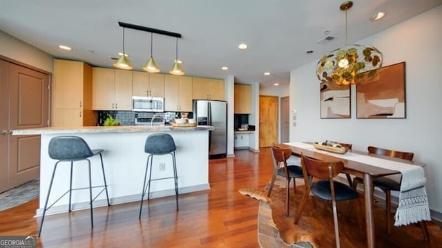 860 Peachtree St NE Unit 917, Atlanta, GA 30308 - kitchen with stainless steel appliances, a breakfast bar, backsplash, recessed lighting, and dark wood-type flooring