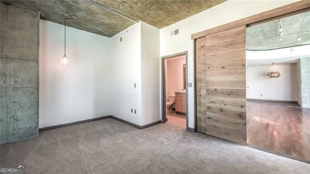 carpeted spare room featuring visible vents and baseboards