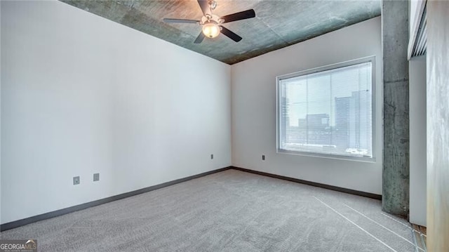 empty room featuring carpet floors, ceiling fan, and baseboards