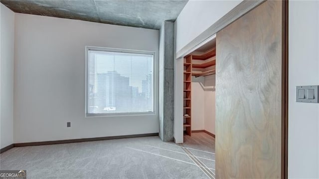 unfurnished bedroom featuring carpet floors, baseboards, and a closet