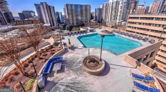 pool with a view of city, an outdoor fire pit, and a patio area