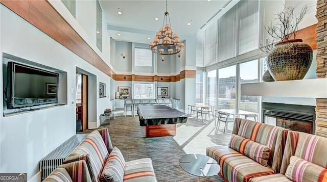 interior space featuring recessed lighting, a high ceiling, a fireplace, carpet, and an inviting chandelier