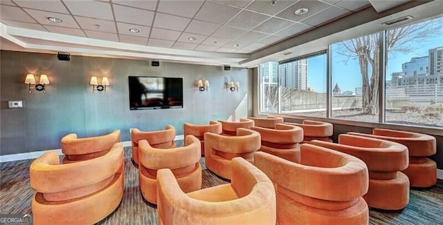 home theater room with baseboards, visible vents, and a drop ceiling