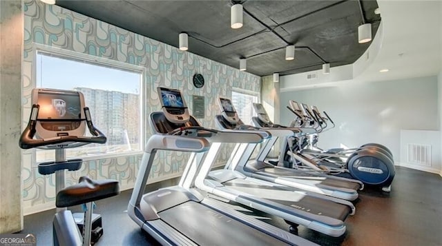 exercise room featuring baseboards, visible vents, and wallpapered walls