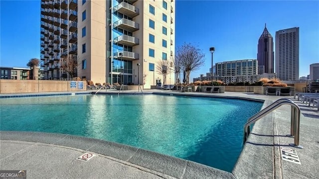 community pool with a city view and a patio