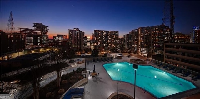 community pool with a patio and a city view