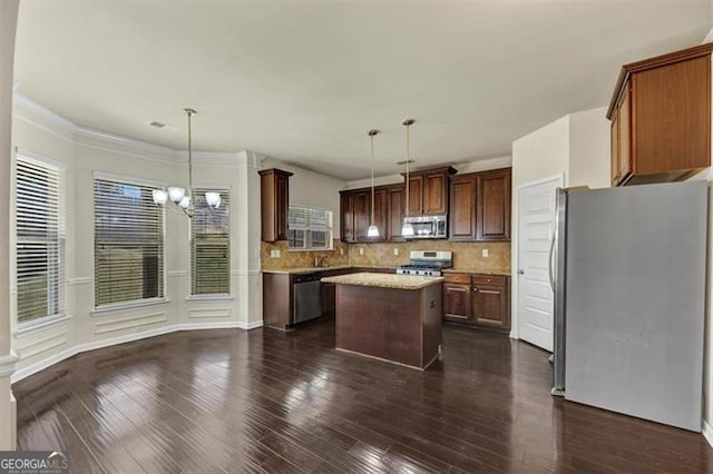 kitchen featuring appliances with stainless steel finishes, decorative backsplash, and dark wood finished floors