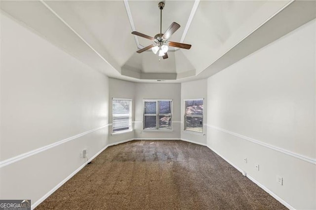 carpeted spare room with a ceiling fan, a raised ceiling, and baseboards