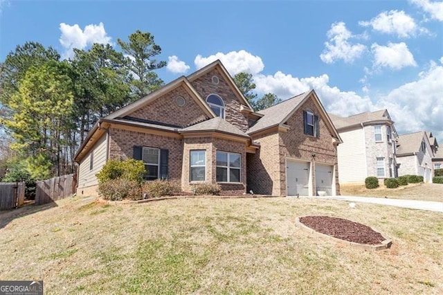 traditional-style house featuring brick siding, a front yard, fence, a garage, and driveway