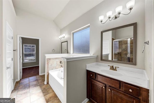 bathroom featuring a garden tub, lofted ceiling, a stall shower, vanity, and baseboards