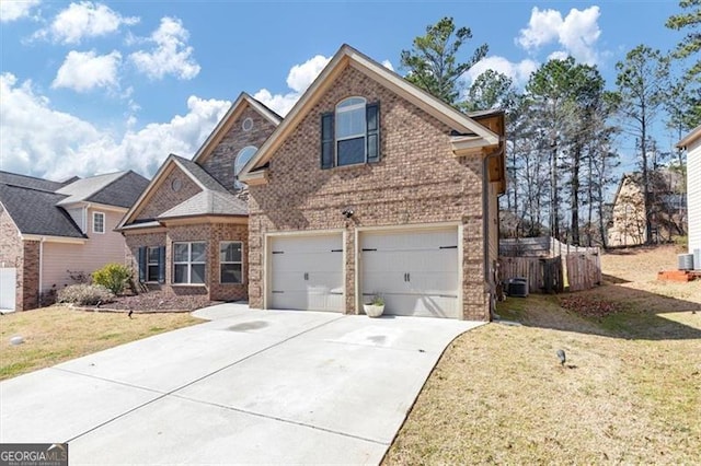 traditional-style home with driveway, an attached garage, a front lawn, and brick siding