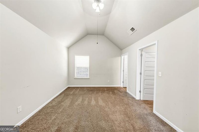 additional living space featuring baseboards, visible vents, vaulted ceiling, and carpet flooring