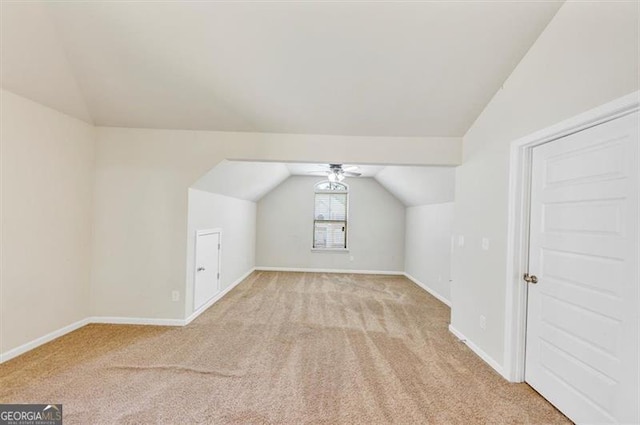 additional living space with a ceiling fan, lofted ceiling, light carpet, and baseboards