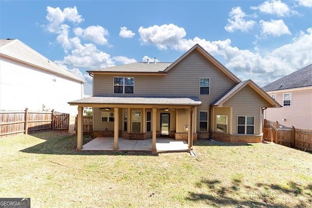 back of property featuring a patio area, a fenced backyard, a lawn, and brick siding