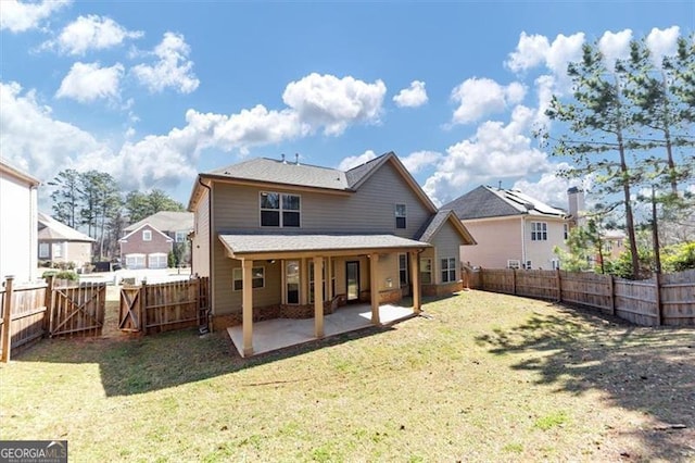 back of house with a fenced backyard, a patio, and a lawn