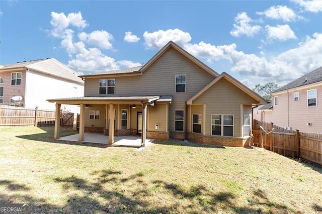 back of property featuring a fenced backyard, brick siding, a ceiling fan, a yard, and a patio area