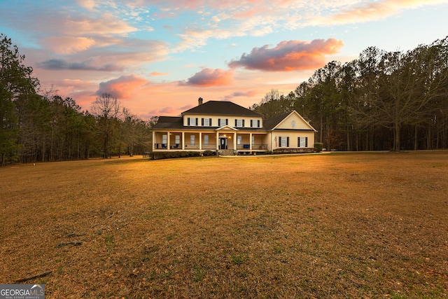 view of front of property featuring a porch and a lawn