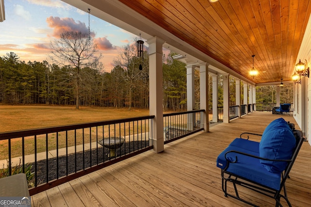 deck with covered porch and a yard