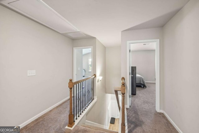 hall with carpet, an upstairs landing, and baseboards