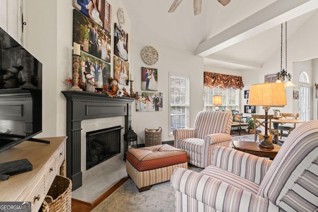 living room featuring a fireplace, high vaulted ceiling, and a ceiling fan