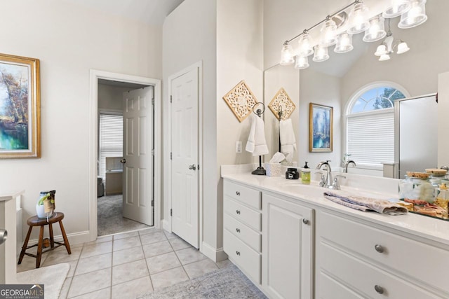 full bath with tile patterned flooring, baseboards, vaulted ceiling, and vanity