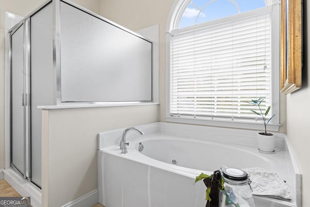 full bathroom featuring a shower stall and a bath