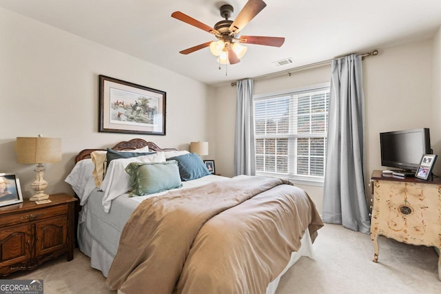 bedroom with visible vents, a ceiling fan, and light colored carpet