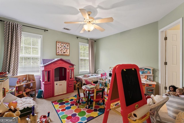 recreation room featuring carpet floors, visible vents, and ceiling fan