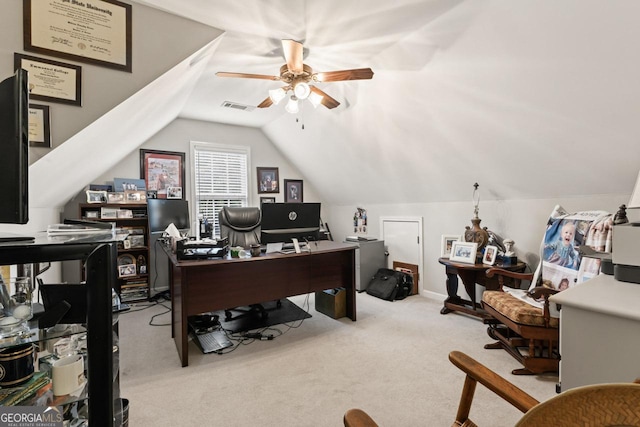 carpeted home office featuring a ceiling fan, visible vents, and vaulted ceiling