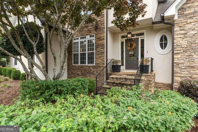 property entrance with stone siding and stucco siding