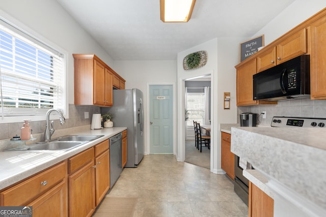 kitchen featuring dishwasher, electric stove, light countertops, black microwave, and a sink