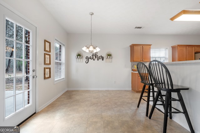 dining room featuring an inviting chandelier, baseboards, and visible vents