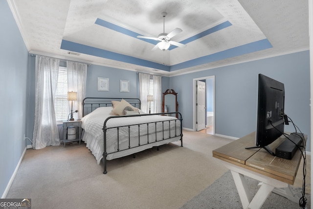 carpeted bedroom featuring ornamental molding, a tray ceiling, visible vents, and baseboards