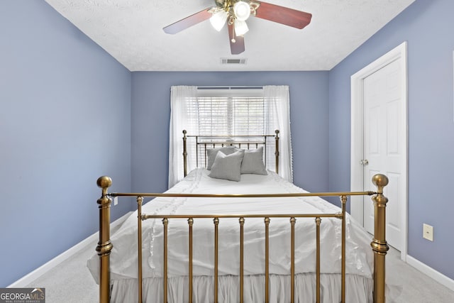 bedroom featuring baseboards, visible vents, a textured ceiling, and carpet flooring